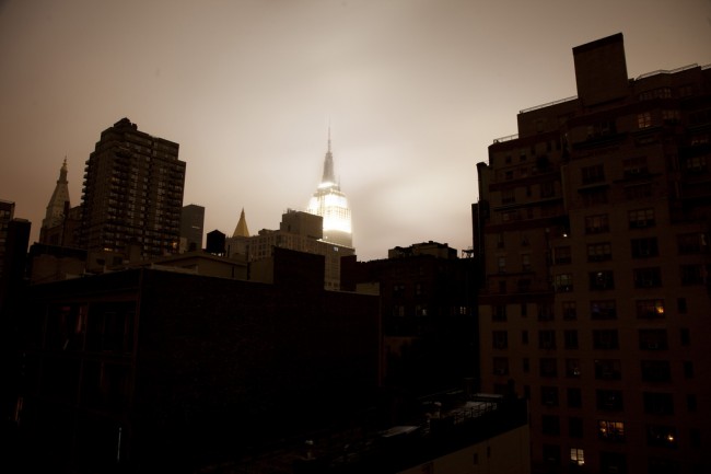 The Empire State Building lights up the sky over a powerless lower Manhattan | Photo via Christopher Schoenbohm